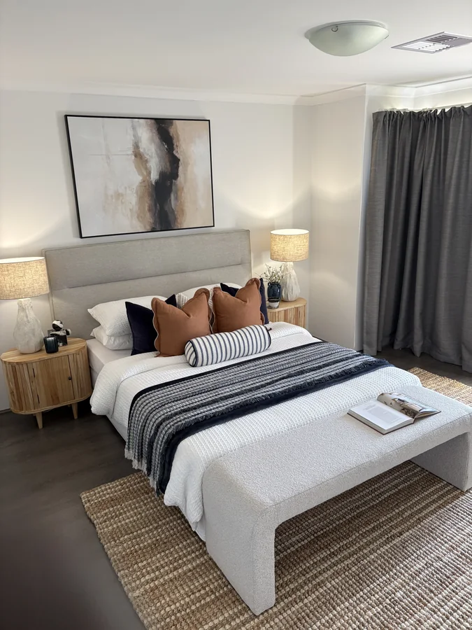 Bedroom with navy and terracotta cushions, timber bedside tables and an upholstered bench